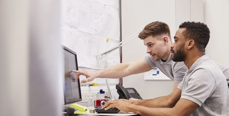 two young engineers working in front of computer