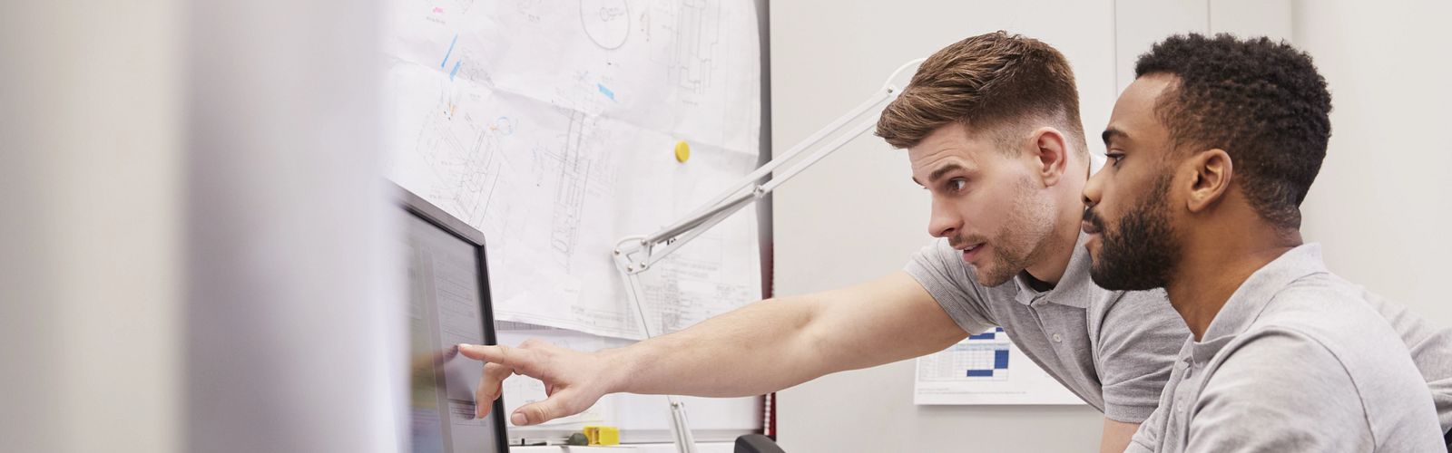 two young engineers working in front of computer