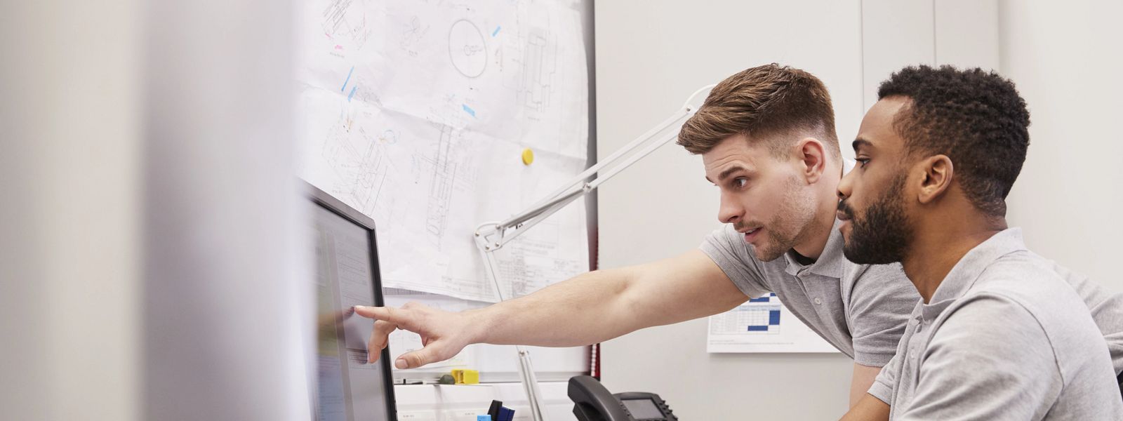 two young engineers working in front of computer